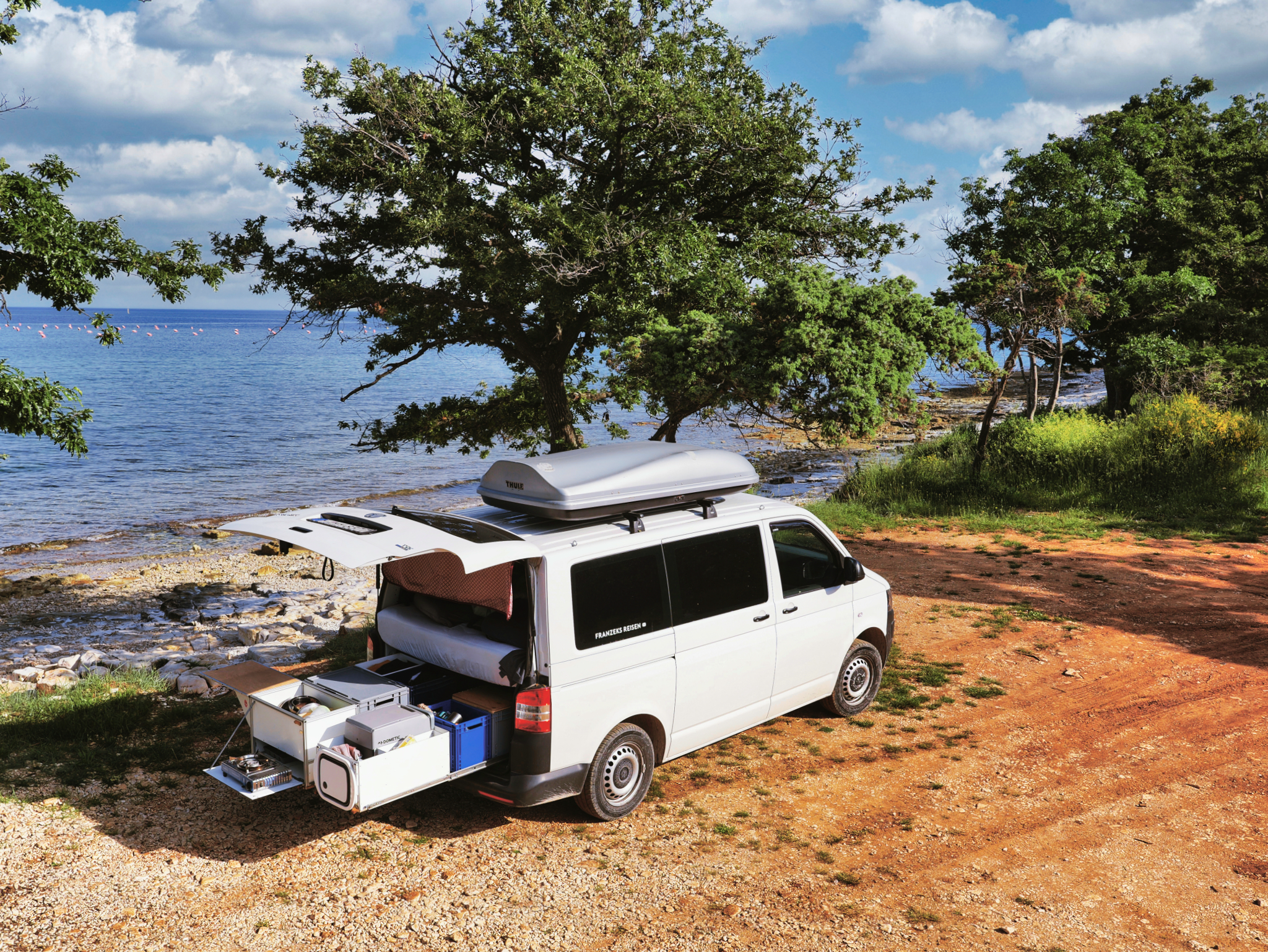 Campervan vor Meer mit Heckklappe offen