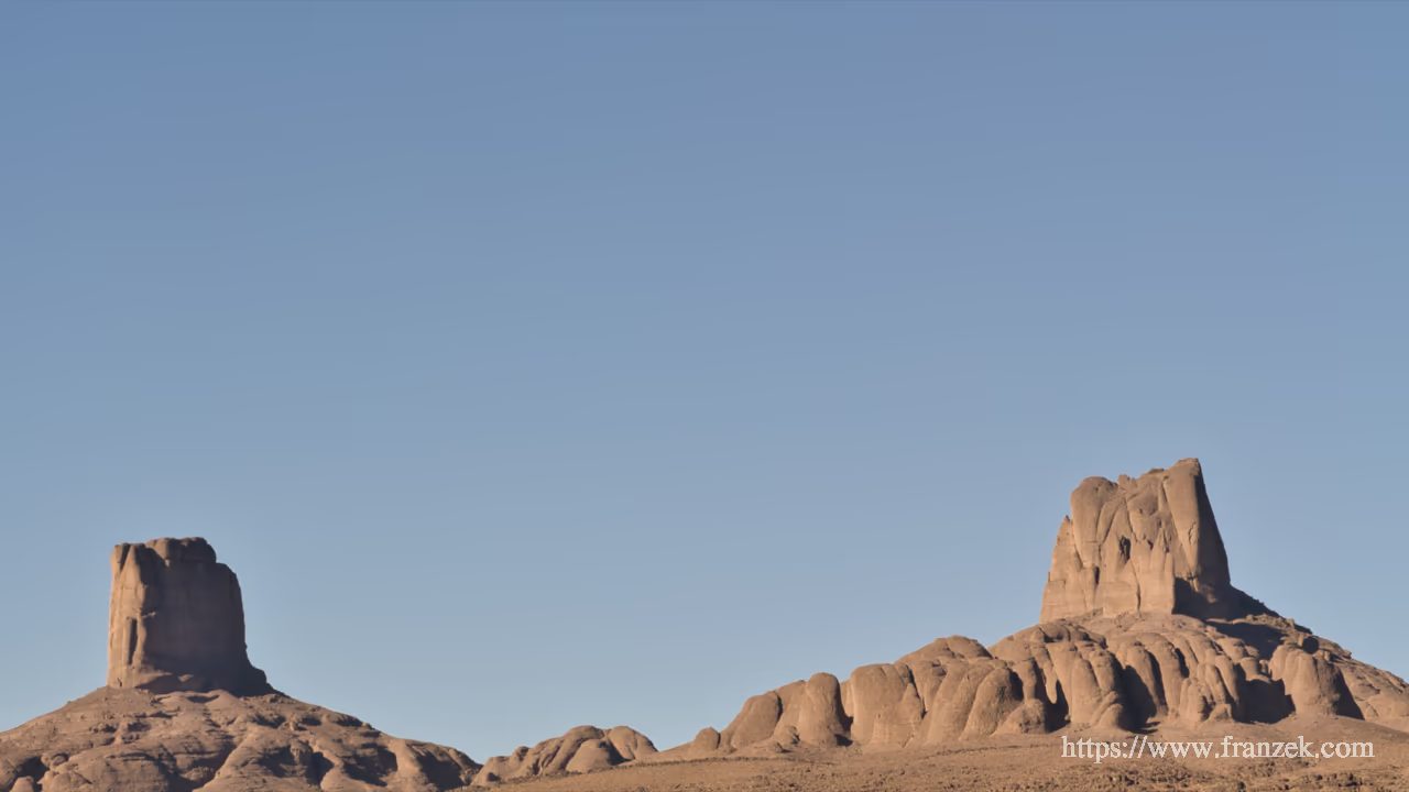 Süd-Marokko Mietwagen-Route: Kosten & Tipps (Anti-Atlas) 56 Die zwei markanten, hohen Felstürme von Bab n'Ali ragen steil vor einem blauen Himmel im Saghro-Gebirge auf.