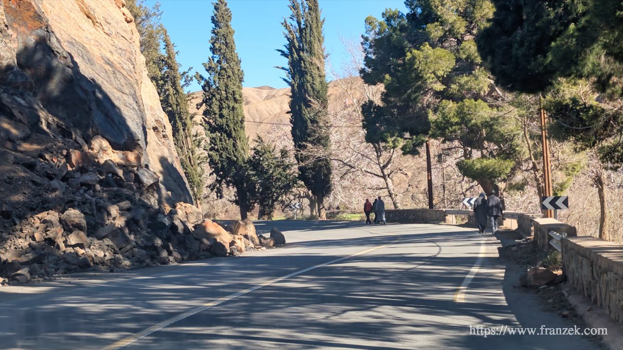 Süd-Marokko Mietwagen-Route: Kosten & Tipps (Anti-Atlas) 67 Felssturz an einer Nationalstraße, rechts laufen Menschen.