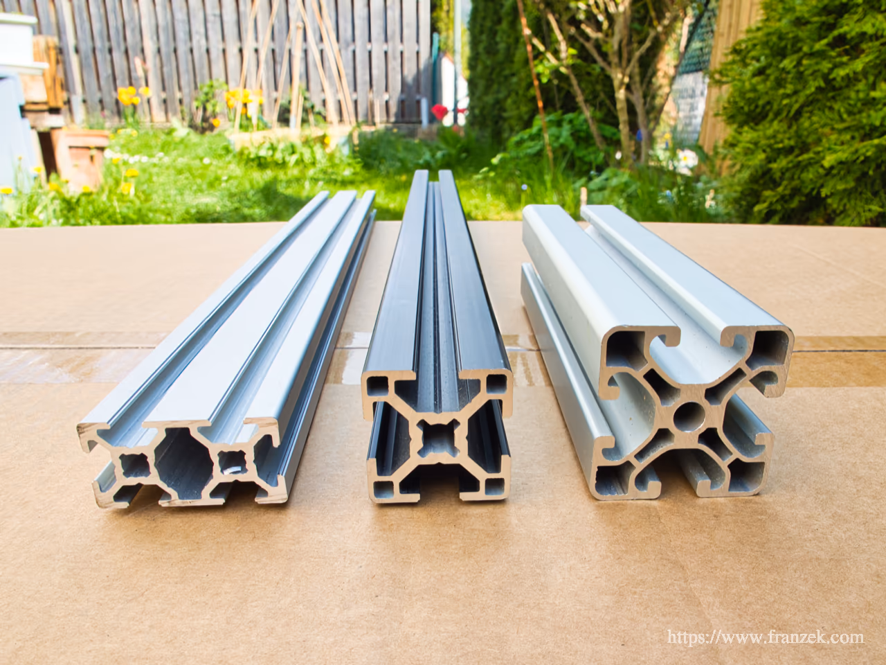Startseite 6 Drei Aluprofile im direkten Größenvergleich nebeneinander: 20x40 Doppelprofil links, 30x30 Profil mittig, 40x40 Profil rechts