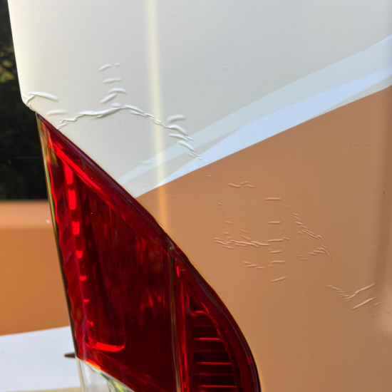 Kastenwagen selbst folieren: Dein Guide fürs Fahrzeugbranding 18 Heck-Detail: Folie wird ums Rücklicht gearbeitet, kleine Falte vor dem Nachföhnen